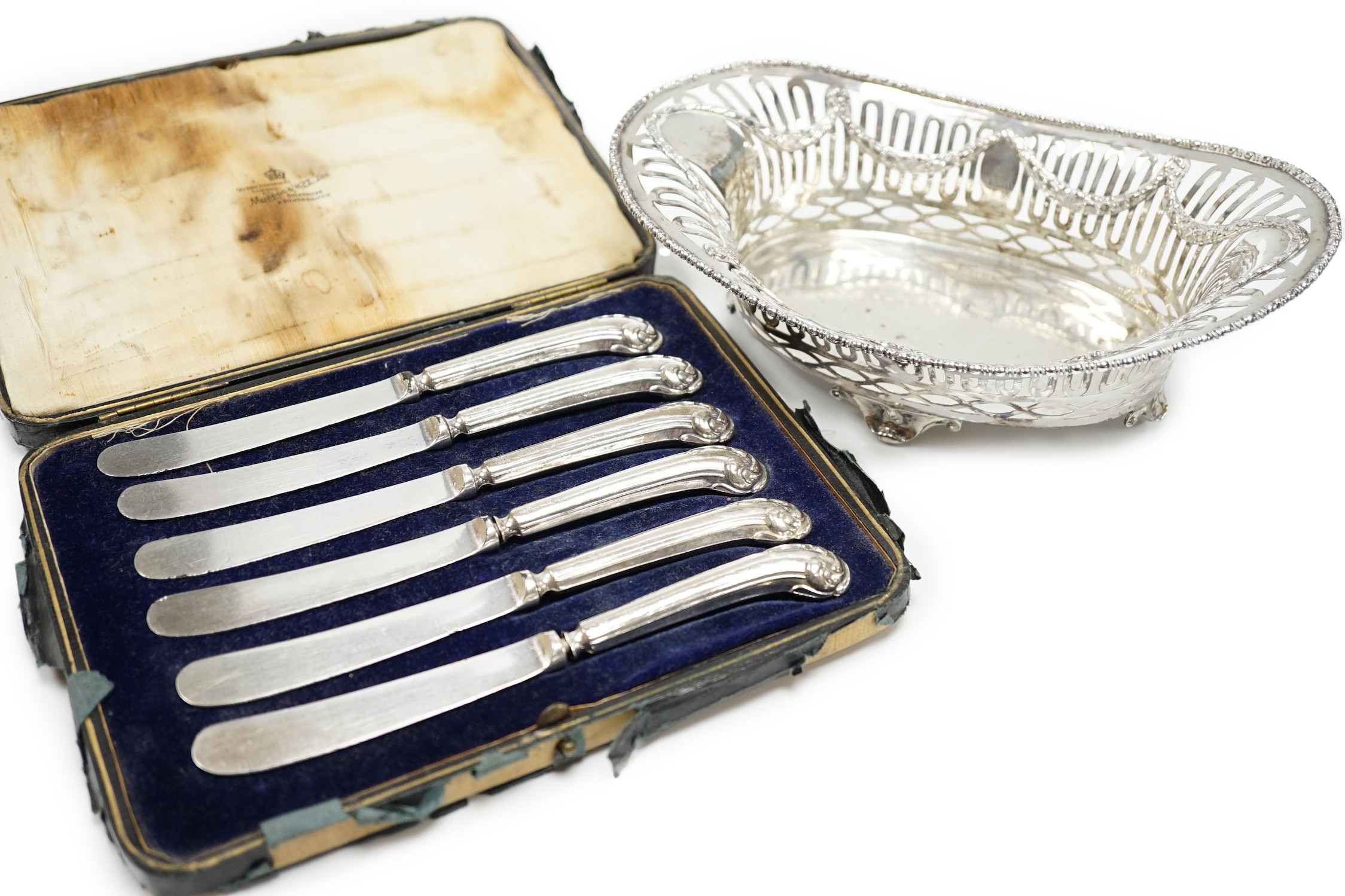 A George V pierced silver oval bowl, 21cm, London, 1912, 5.5oz and a cased set of six silver pistol handled steel tea knives.